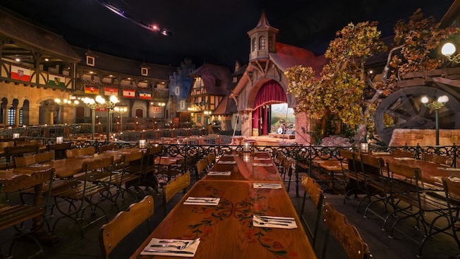 Long communal dining tables across from a stage in Biergarten Restaurant in Germany Pavilion at Epcot 