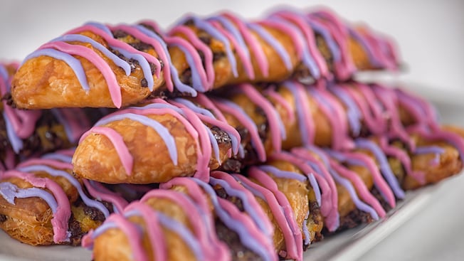 A stack of several pastries drizzled with brightly colored icing