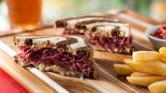 Rueben sandwich with marbled rye bread and fries on a cutting board