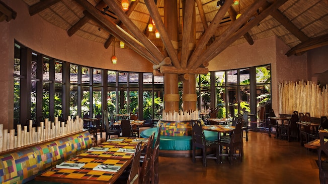 Dining area at Boma—Flavors of Africa, featuring a thatched ceiling and windows with a  panoramic garden view