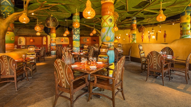 Tribal-design tables under faux tree canopy with hanging lanterns