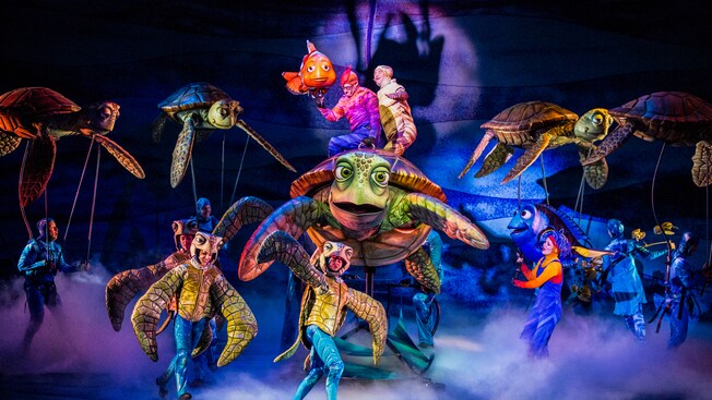 Marlin and sea turtles with their actor counterparts on stage at Finding Nemo - The Musical