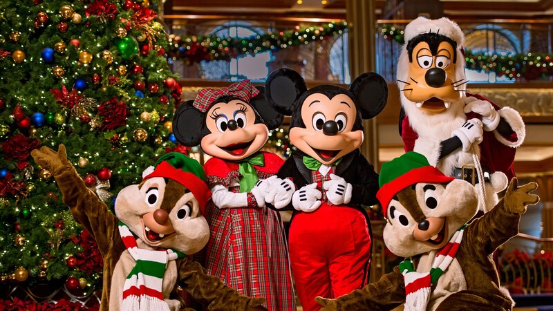 Mickey Mouse, Minnie, Goofy and Chip and Dale posing in front of a Christmas tree