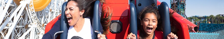 A woman and young girl screaming with excitement while riding the Incredicoaster